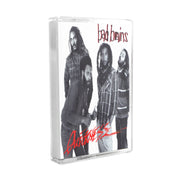 Photo of a the bad brains quickness cassette case against a white background. The artwork is a black and white image of the 4 band members. two band members on the left look at the camera, not smiling. One has his hands in his pockets while the other does a thumbs up. The third member has his hands in his pockets. The fourth member has his eyes closed as if he is asleep. The top right in black writing with a red outline says bad brains. The bottom left in red writing says quickness.
