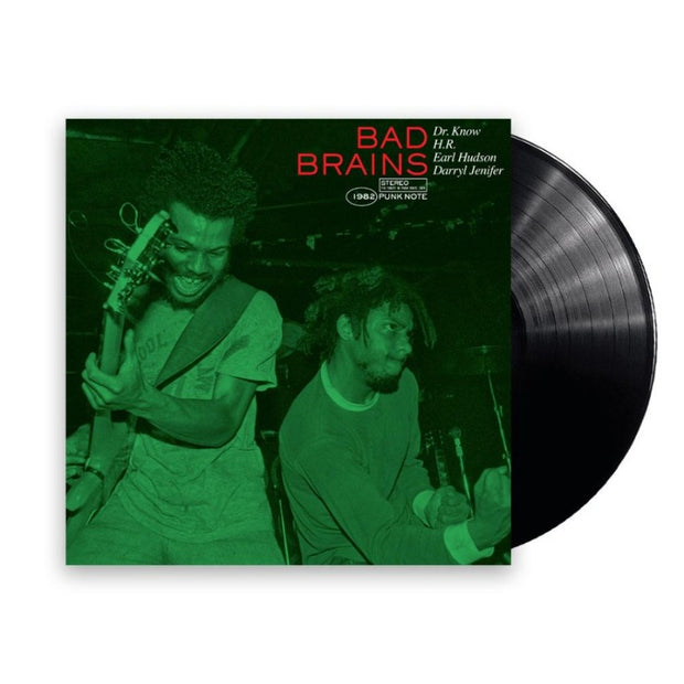 Image of a vinyl sleeve and vinyl against a white background. The vinyl is solid black. The sleeve is a photo of the Bad Brains Punk Note Edition artwork. The artwork is an image of two men playing instruments next to each other and the image is in green. One looks happy while the other looks focused. Above their heads on the top right in red text says Bad Brains. In white text next to it says Dr. Know, H.R., Earl Hudson, Darryl Jenifer. Under the bad brains words says 1982, stereo, punk note in white.