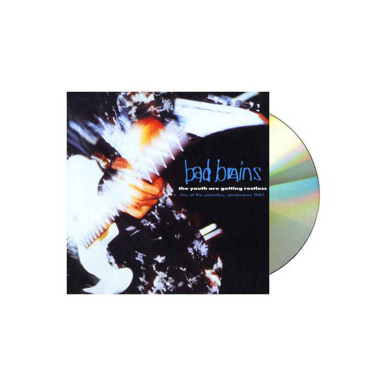 Photo of the bad brains the youth are getting restless (live at the paradise, amsterdam 1987) cd sleeve and silver cd. The album artwork on the sleeve is a close up photo of someone playing a guitar, you see their hand and the guitar. The image has a faded and blurred effect to it. The right side of the album artwork says bad brains in blue. Below that in white text says The youth are getting restless. Below that in blue text says live at the paradise, amsterdam 1987.
