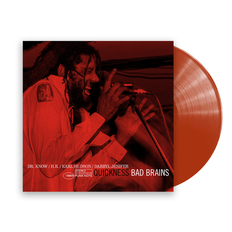 Image of a vinyl sleeve and red vinyl against a white background. The vinyl sleeve is an Image of the bad brains- quickness punk note edition album cover. The artwork is a red photograph of the lead singer singing into a microphone. At the bottom of the image in white letters it says "Dr. Know, H.R., Earl Hudson, Darryl Jenifer. 1989 stereo punk note. In black text it says quickness. Next to that in white text it says bad brains.