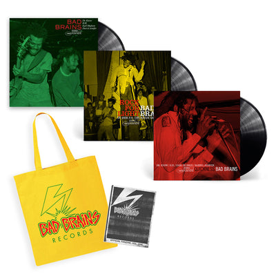 photo of 3 bad brains records with the members on the front of the covers- one cover is green for self titled album, another yellow for rock for light, and red for the quickness album. there is a yellow tote bag with the bad brains records logo on it that features the lightning bolt and red and green text logo, and a black and white fanzine with this logo on it as well. 