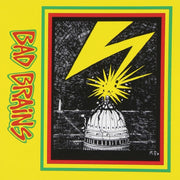 Image of the Bad Brains self titled artwork. the artwork is yellow and on the left side going down the image is a sideways lettering that says Bad Brains. The letters are red and outlined in yellow, and then outlined again in green. On the right side of the artwork is a rectangle with the same red, yellow, green outline. Inside the outlines is a black and white drawn image of the Capitol Building being struck by yellow lightning.